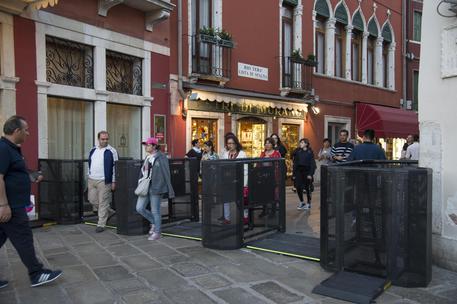 Sono stati installati a Venezia i primi tornelli in metallo che serviranno da questo week end per fermare e deviare i turisti nel caso di eccessivo afflusso, 27 aprile 2018. Sarà la polizia municipale, in base all'ordinanza del sindaco, a decidere quando scatterà il blocco: i tornelli - uno vicino al Ponte di Calatrava, l'altro all'imbocco di lista di Spagna - daranno sempre via libera ai residenti, si chiuderanno invece per i turisti diretti a San Marco o Rialto, che verranno deviati su itinerari alternativi. ANSA/RICCARDO GREGOLIN